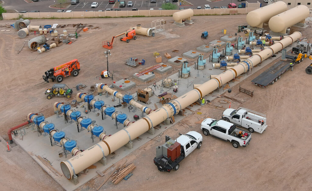 An aerial view of a Water Treatment Plant construction site with large pipes and trucks at 24th St.