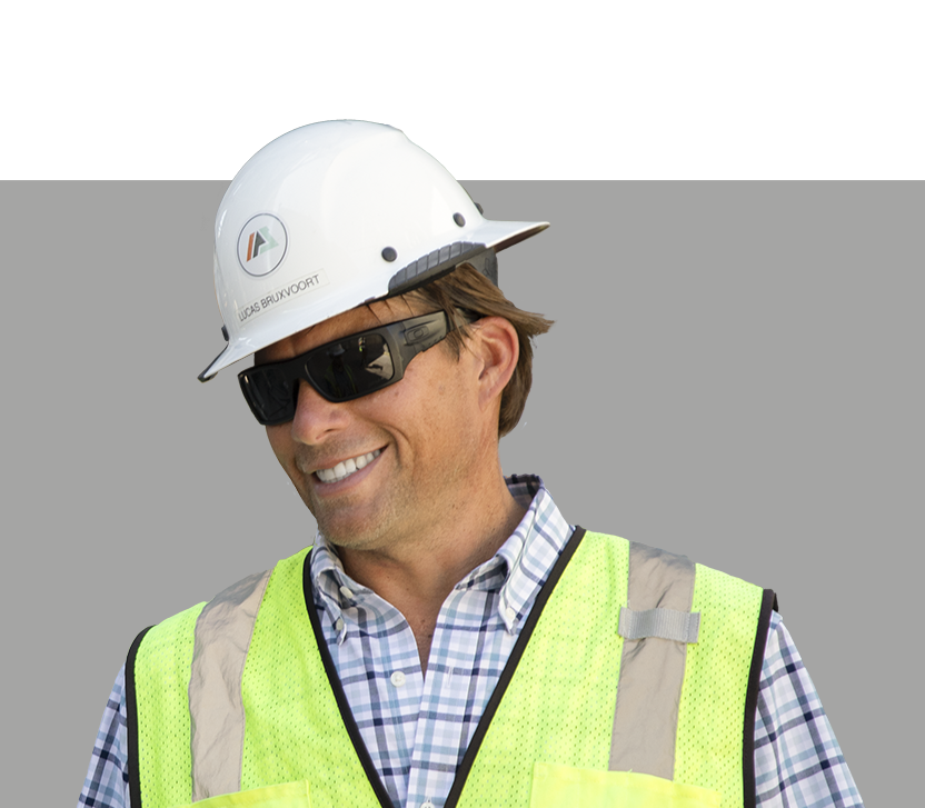 A man wearing a hard hat and sunglasses evaluates custom automation solutions.