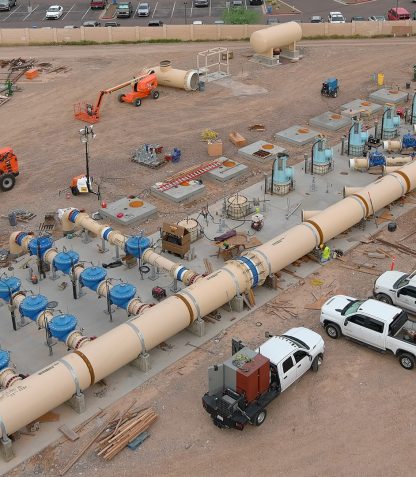 An aerial view of a Water Treatment Plant construction site with large pipes and trucks at 24th St.